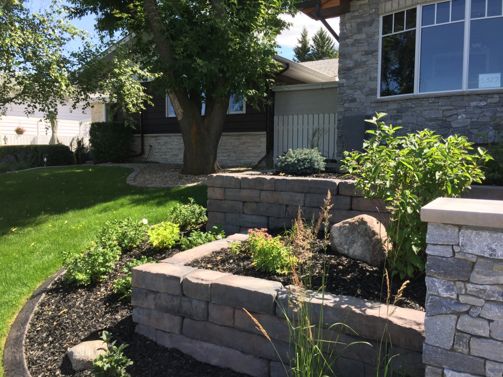 Inspiration for a mid-sized front yard garden in Calgary with with raised garden bed and mulch.
