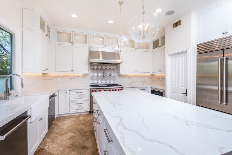 Enclosed kitchen - mid-sized transitional l-shaped porcelain tile and beige floor enclosed kitchen idea in Orange County with recessed-panel cabinets, white cabinets, quartz countertops, white backsplash, marble backsplash, stainless steel appliances, an island and a farmhouse sink