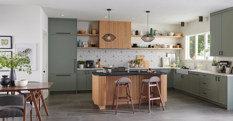 Klassische Küche mit Landhausspüle, Schrankfronten im Shaker-Stil, grünen Schränken, Küchenrückwand in Weiß, grauem Boden und weißer Arbeitsplatte