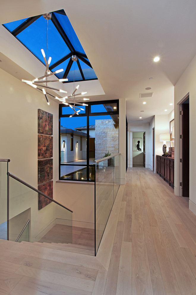Design ideas for a large contemporary hallway in Orange County with white walls and light hardwood floors.