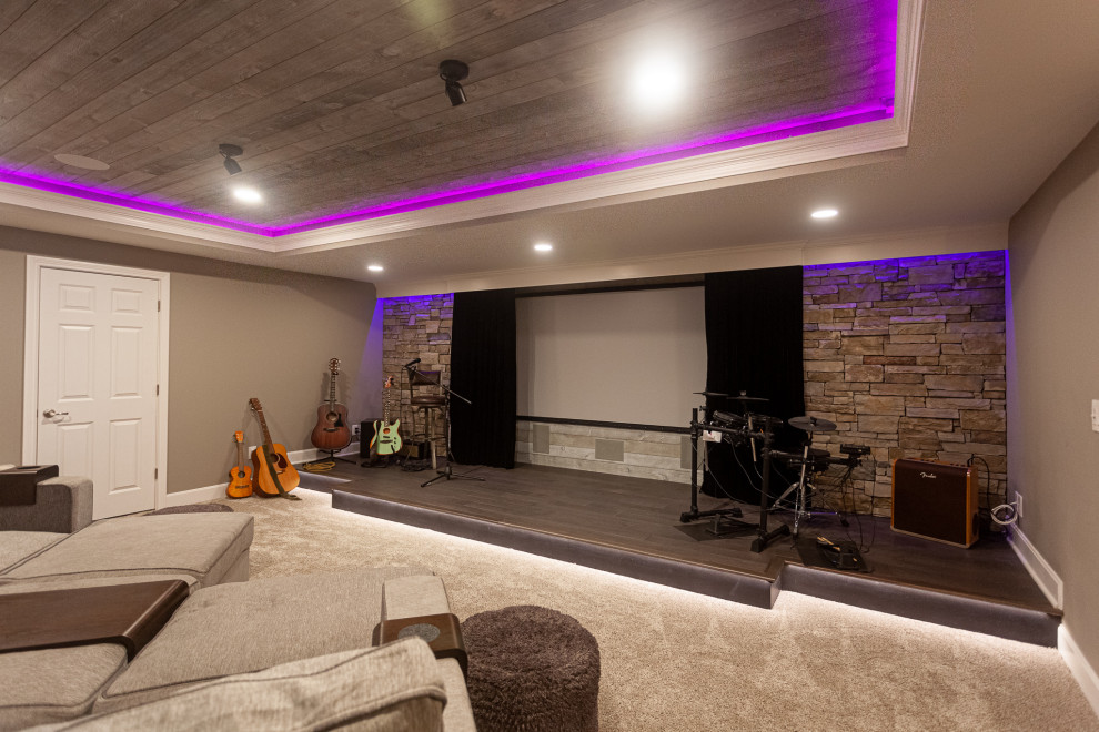 Inspiration for an expansive classic look-out basement in Cincinnati with a home cinema, grey walls, carpet, beige floors and a vaulted ceiling.