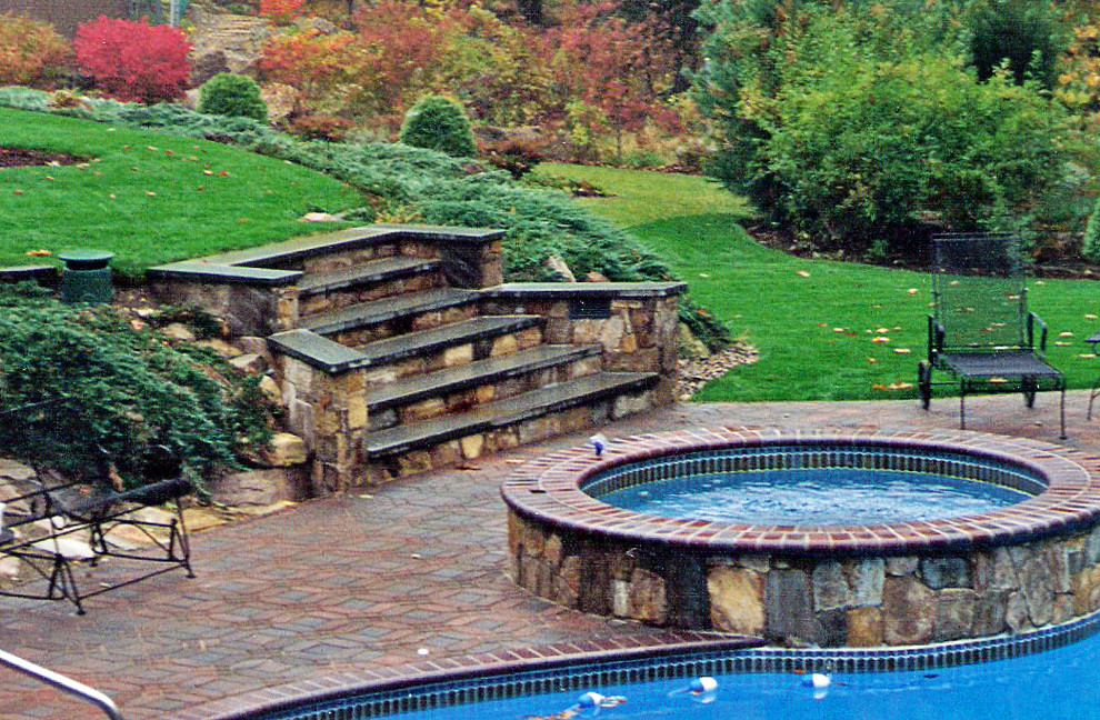 Traditional backyard pool in Providence with natural stone pavers.