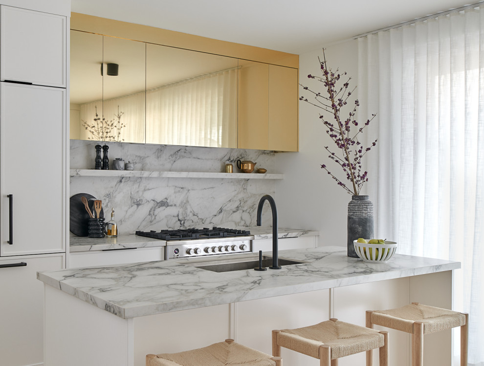 Inspiration for a transitional galley kitchen remodel in Toronto with an undermount sink, flat-panel cabinets, white cabinets, stainless steel appliances, an island and gray countertops
