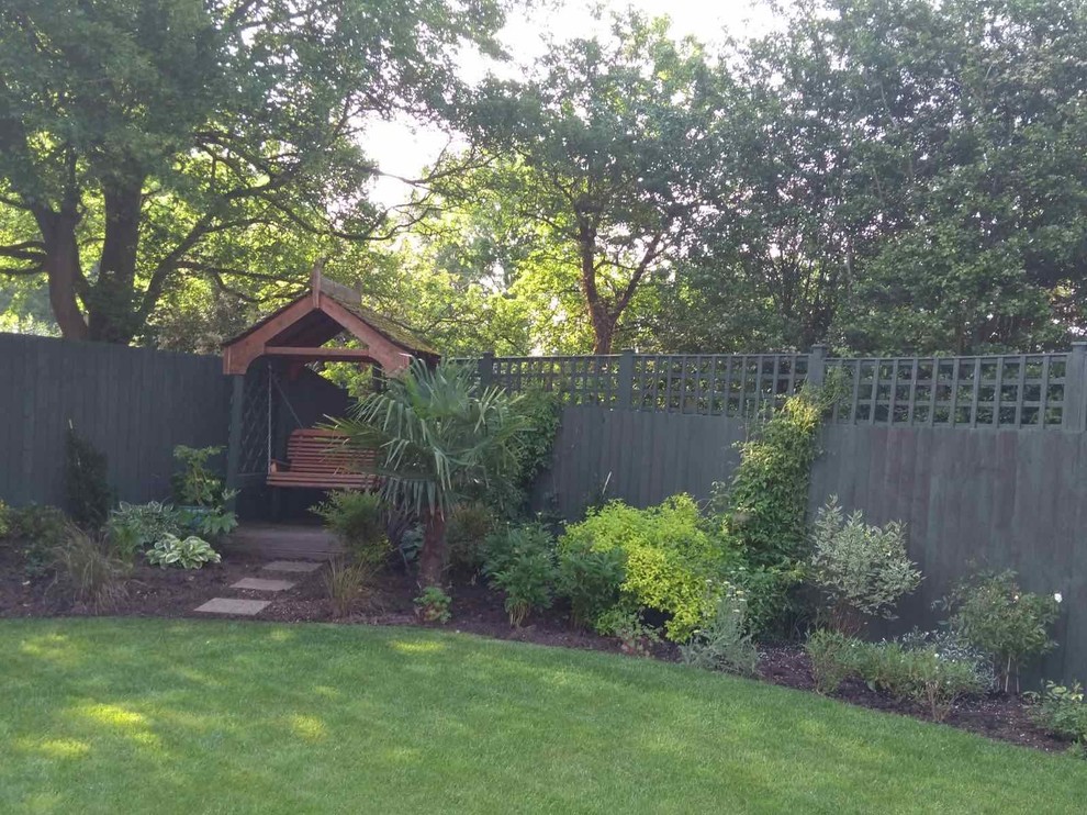 This is an example of a mid-sized traditional backyard partial sun garden for summer in Other.