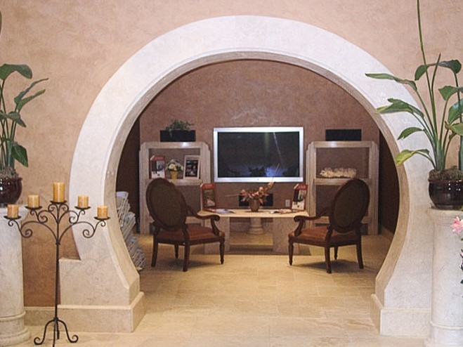 Photo of a mid-sized mediterranean enclosed home theatre in Phoenix with beige walls, travertine floors and a wall-mounted tv.