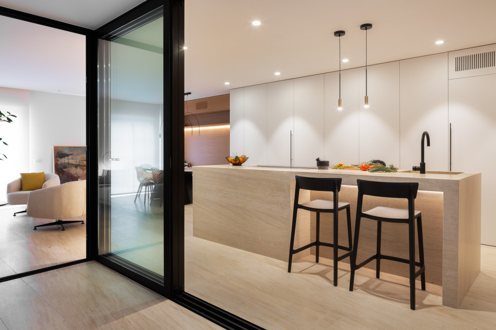 Design ideas for a modern single-wall open plan kitchen in Alicante-Costa Blanca with flat-panel cabinets, white cabinets, limestone benchtops, limestone floors, with island, brown floor and brown benchtop.