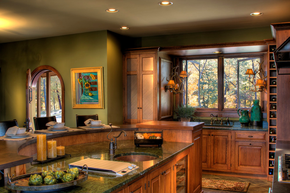 Example of a mountain style slate floor kitchen design with an undermount sink, light wood cabinets, paneled appliances and subway tile backsplash