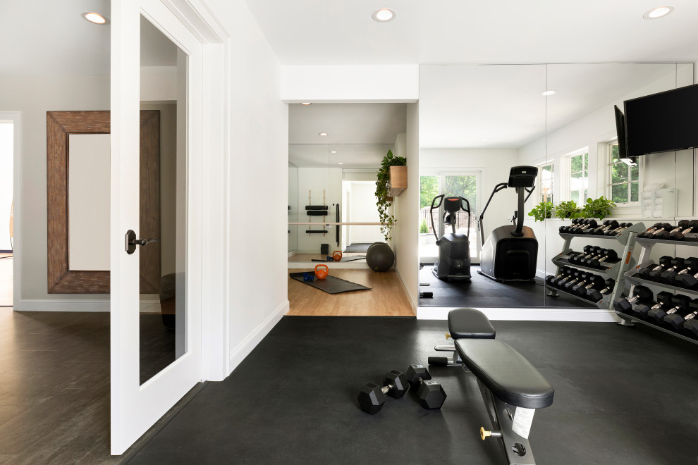Photo of a transitional home weight room in Minneapolis with white walls and black floor.