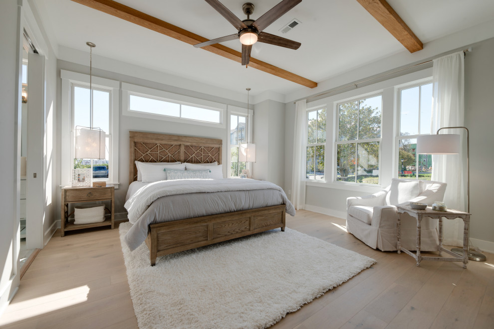 Ejemplo de dormitorio principal marinero grande con paredes grises, suelo de madera clara, suelo gris y vigas vistas