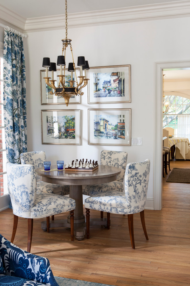This is an example of a traditional dining room in San Diego with white walls, medium hardwood floors and no fireplace.