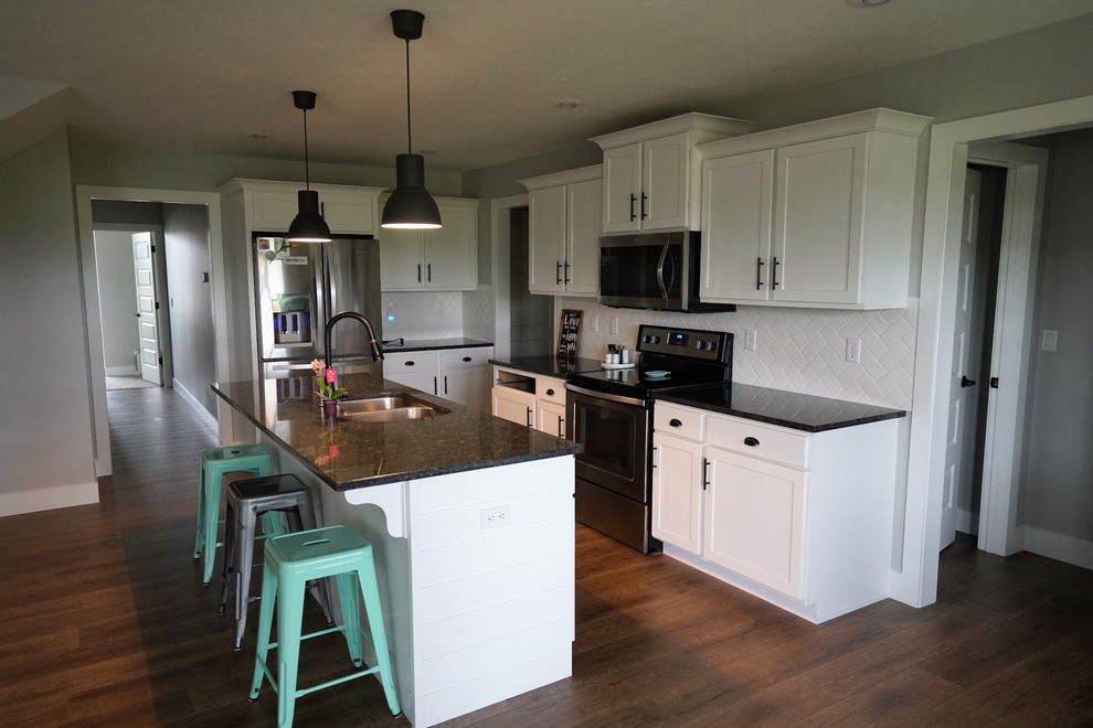 Eat-in kitchen - mid-sized transitional l-shaped dark wood floor and brown floor eat-in kitchen idea with an undermount sink, shaker cabinets, white cabinets, onyx countertops, white backsplash, subway tile backsplash, stainless steel appliances and an island