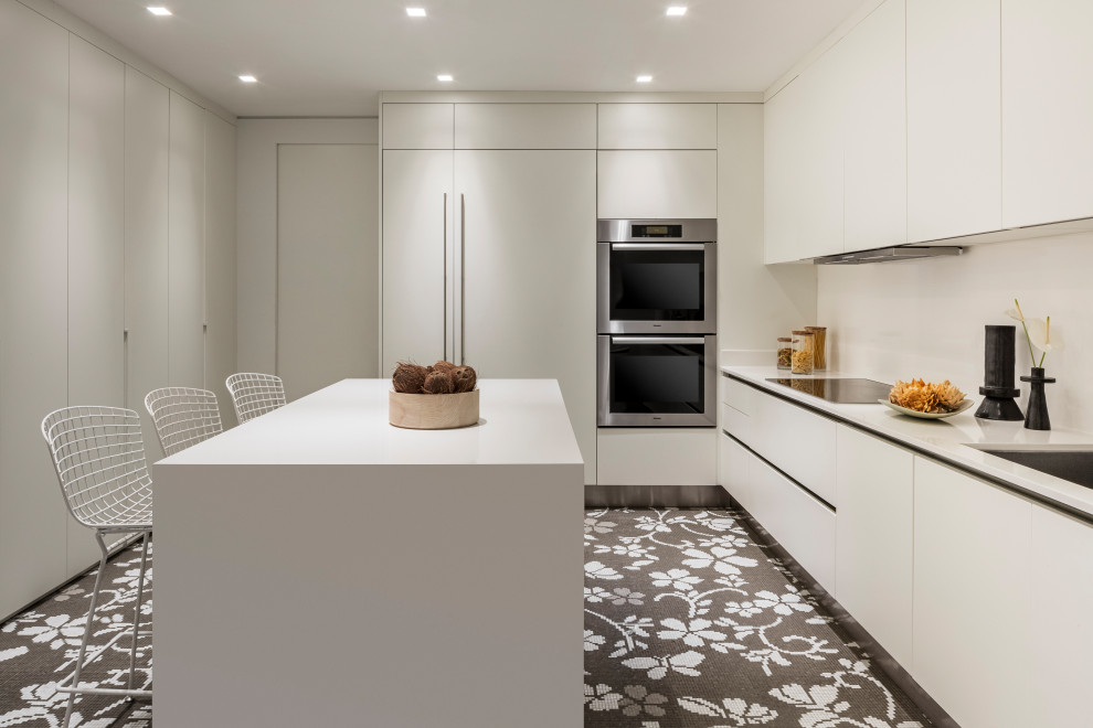 Foto di una cucina minimalista di medie dimensioni con lavello sottopiano, ante bianche, paraspruzzi bianco, elettrodomestici bianchi, pavimento grigio e top bianco