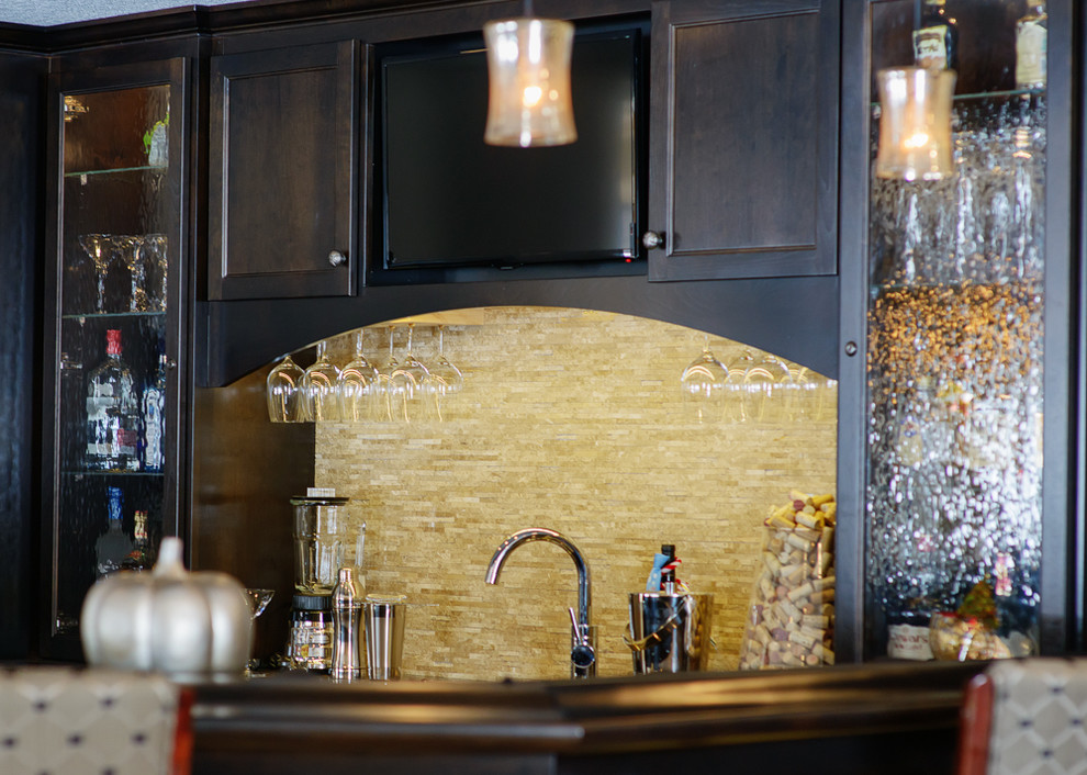 Mid-sized transitional galley home bar in Minneapolis with shaker cabinets, dark wood cabinets, beige splashback and stone tile splashback.