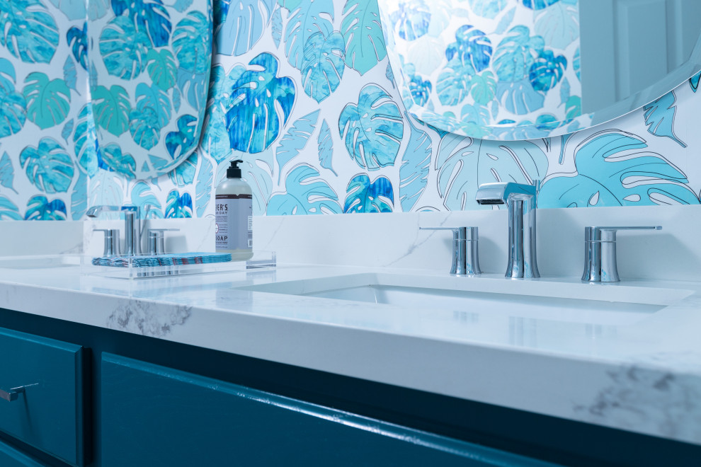Mittelgroßes Kinderbad mit profilierten Schrankfronten, blauen Schränken, Badewanne in Nische, Duschbadewanne, blauen Fliesen, Porzellanfliesen, weißer Wandfarbe, Porzellan-Bodenfliesen, Unterbauwaschbecken, Quarzwerkstein-Waschtisch, beigem Boden, Schiebetür-Duschabtrennung, weißer Waschtischplatte, WC-Raum, Doppelwaschbecken, eingebautem Waschtisch und Tapetenwänden in San Diego