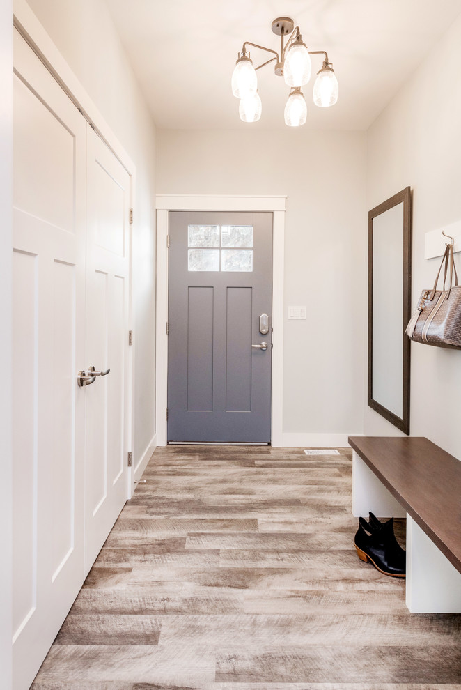 Photo of a mid-sized transitional front door in Other with grey walls, vinyl floors, a single front door, a gray front door and brown floor.