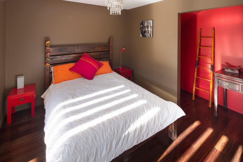 Mid-sized contemporary guest bedroom in Sydney with orange walls and medium hardwood floors.