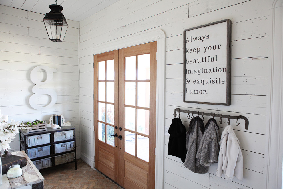 Inspiration for a mid-sized country entryway in Austin with white walls, brick floors, a double front door and a glass front door.