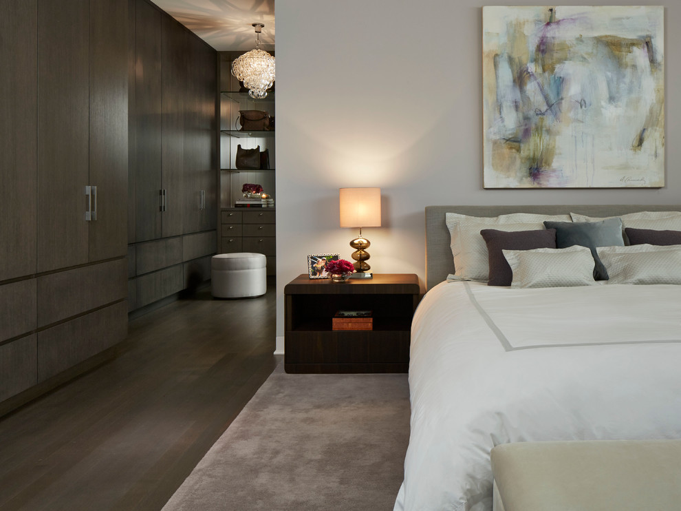 Contemporary bedroom in Chicago with grey walls and dark hardwood floors.