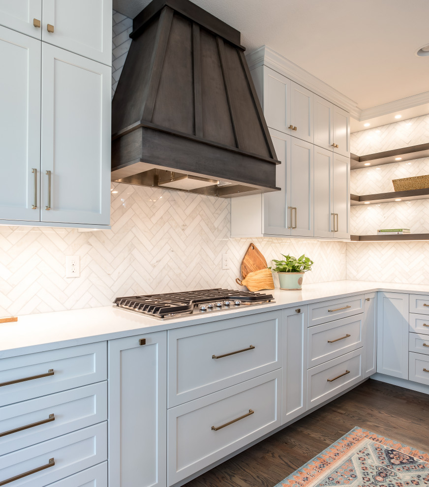 Example of a large transitional galley medium tone wood floor and brown floor open concept kitchen design in Denver with an undermount sink, shaker cabinets, white cabinets, quartz countertops, beige backsplash, marble backsplash, stainless steel appliances, an island and white countertops