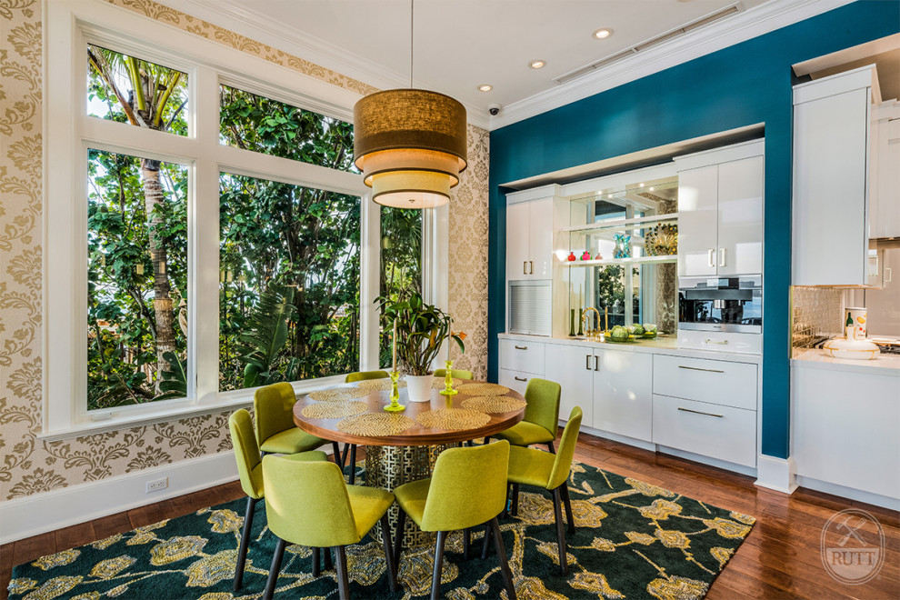 Idée de décoration pour une salle à manger vintage de taille moyenne avec une banquette d'angle, un mur bleu, un sol en bois brun et du papier peint.