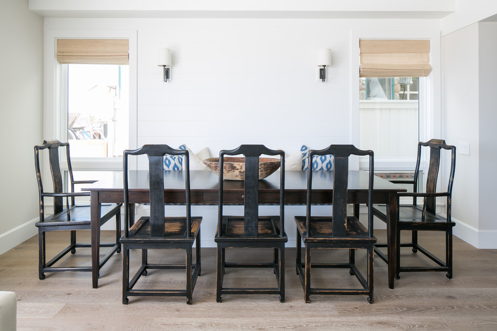 This is an example of a mid-sized beach style open plan dining in Orange County with white walls, medium hardwood floors, no fireplace and brown floor.