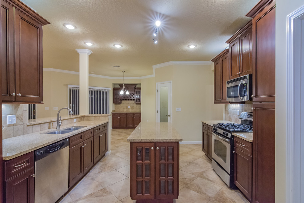 Example of a mid-sized arts and crafts galley ceramic tile and beige floor eat-in kitchen design with a double-bowl sink, recessed-panel cabinets, dark wood cabinets, granite countertops, beige backsplash, ceramic backsplash, stainless steel appliances and an island