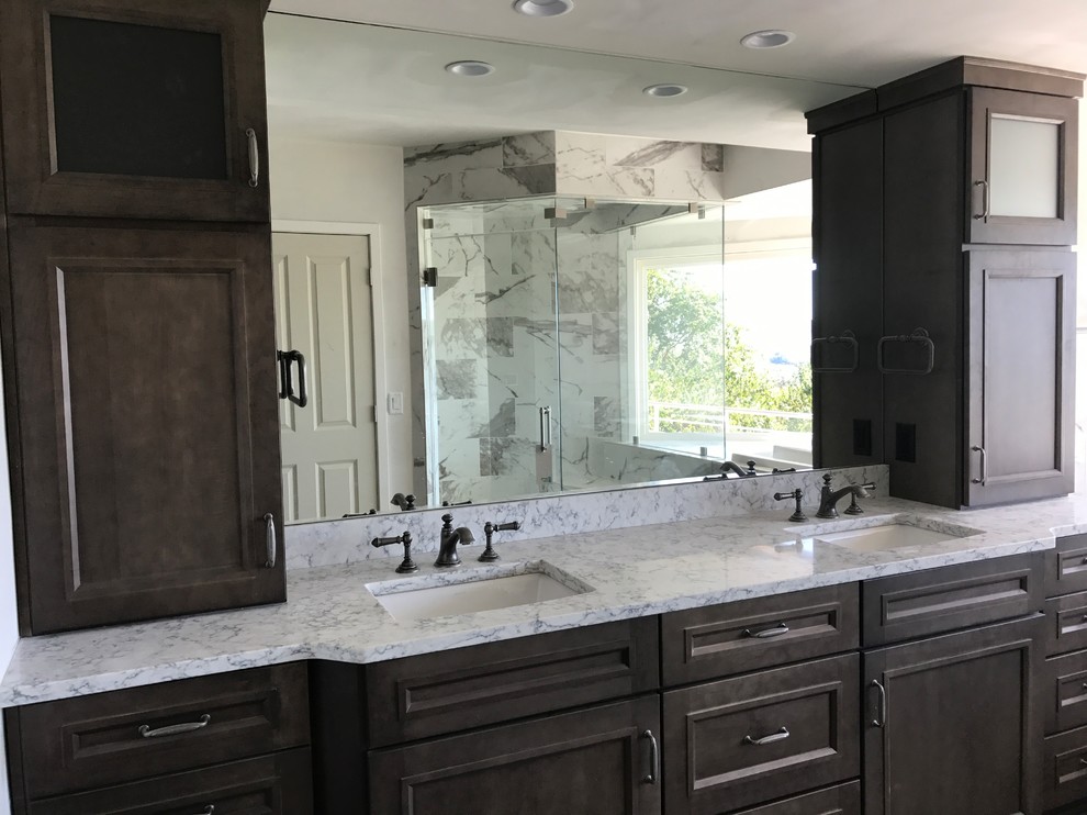 Wet room - mid-sized transitional master gray tile and marble tile porcelain tile and gray floor wet room idea in Cincinnati with recessed-panel cabinets, gray cabinets, an undermount tub, a two-piece toilet, gray walls, an undermount sink, granite countertops, a hinged shower door and gray countertops