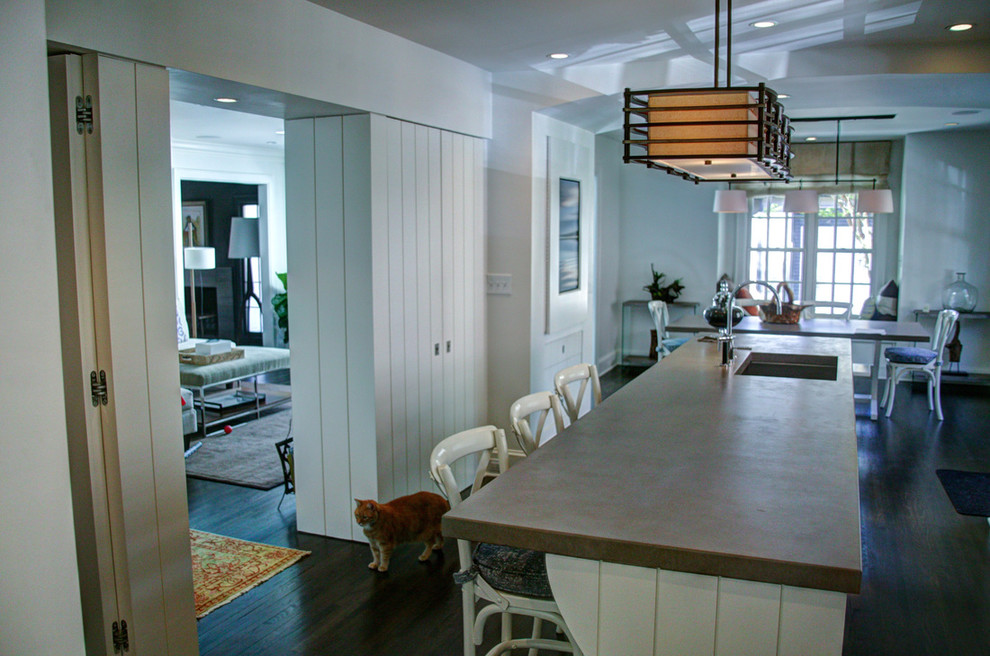 Example of a mid-sized trendy u-shaped dark wood floor eat-in kitchen design in Charlotte with an undermount sink, flat-panel cabinets, white cabinets, white backsplash, ceramic backsplash, stainless steel appliances and an island