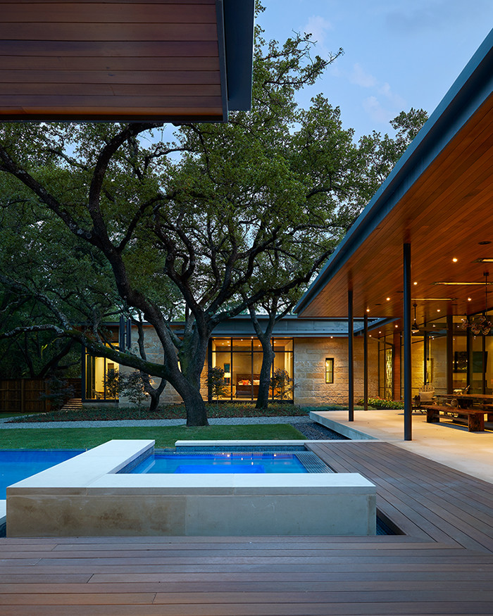 Large contemporary backyard custom-shaped pool in Austin with a hot tub.