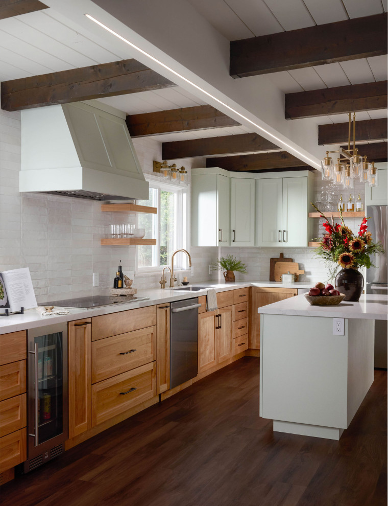 Inspiration for a mid-sized transitional l-shaped medium tone wood floor, brown floor and exposed beam eat-in kitchen remodel with a single-bowl sink, shaker cabinets, medium tone wood cabinets, quartz countertops, white backsplash, subway tile backsplash, stainless steel appliances, an island and white countertops