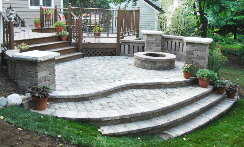 Design ideas for a mid-sized traditional backyard full sun garden with a fire feature and natural stone pavers.