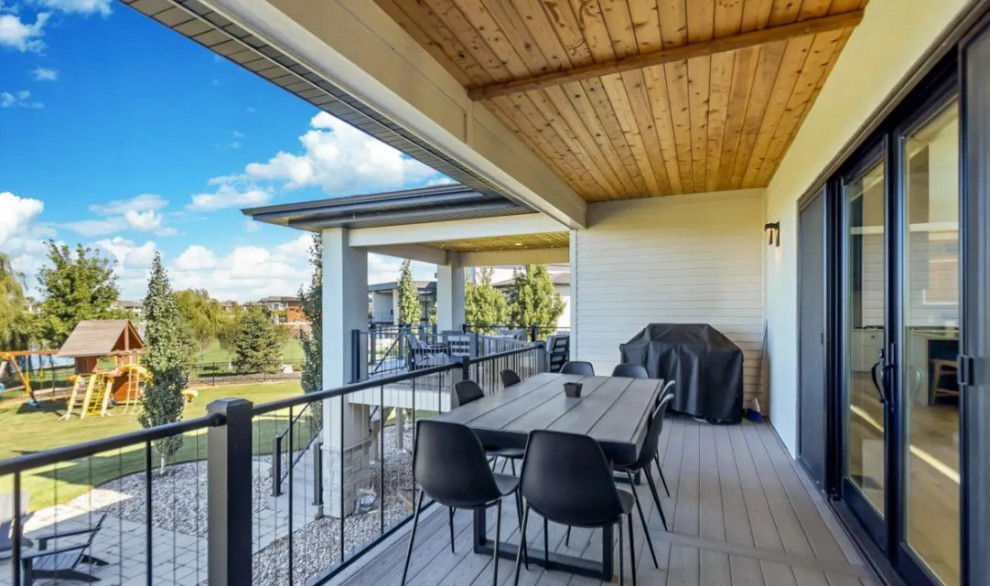 Inspiration for a large transitional backyard second story metal railing deck remodel with a bbq area and a roof extension