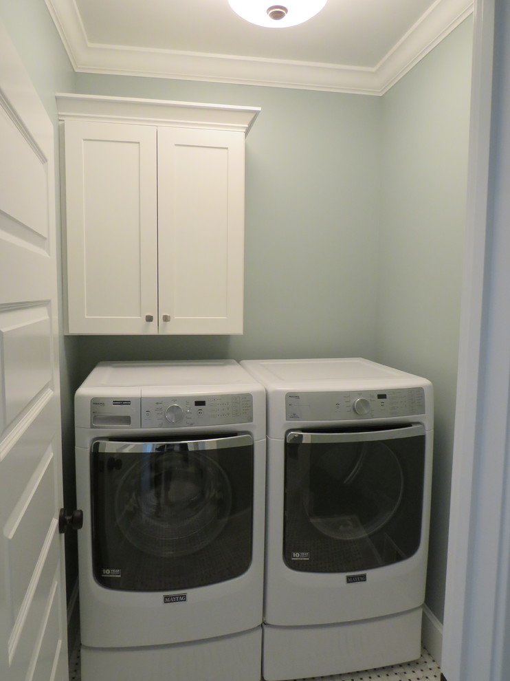 Inspiration for a small country single-wall laundry cupboard in Grand Rapids with shaker cabinets, white cabinets, blue walls, porcelain floors and a side-by-side washer and dryer.