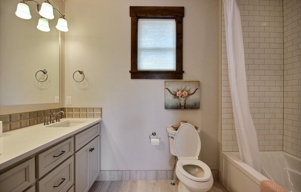 This is an example of a large classic family bathroom in Portland with beige walls, brown floors, recessed-panel cabinets, beige cabinets, an alcove bath, a shower/bath combination, a bidet, beige tiles, glass tiles, ceramic flooring, a submerged sink, engineered stone worktops, a shower curtain, white worktops, double sinks and a built in vanity unit.