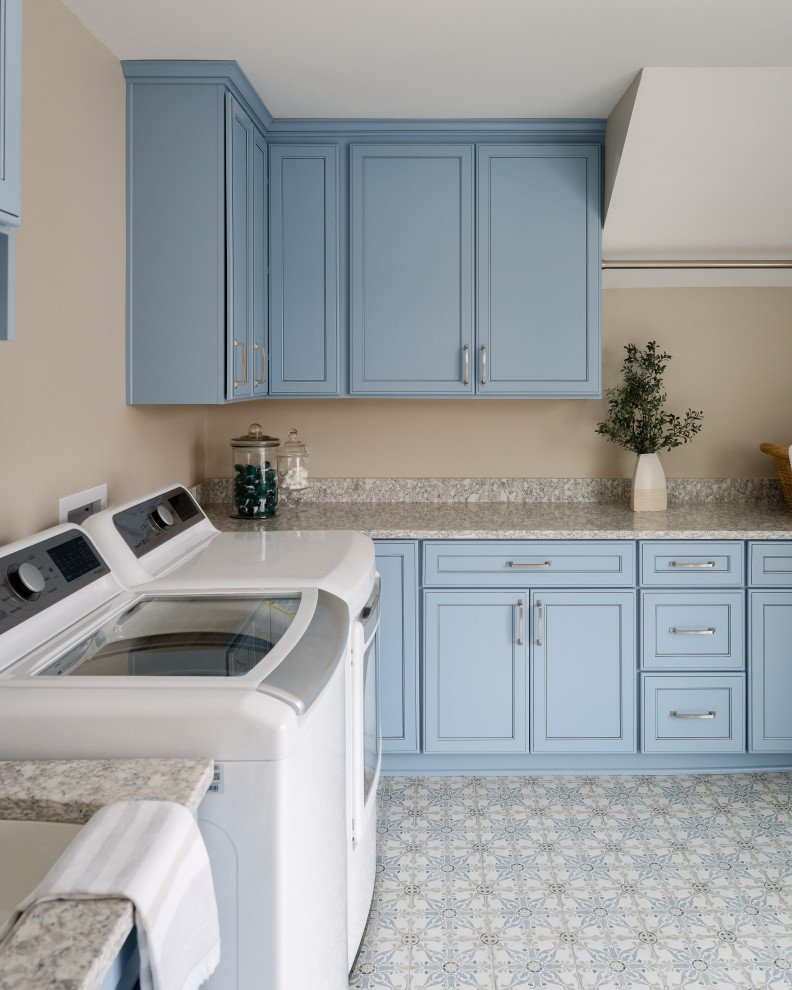 Bild på en mellanstor funkis parallell tvättstuga enbart för tvätt, med en undermonterad diskho, blå skåp, granitbänkskiva, beige väggar, klinkergolv i keramik och en tvättmaskin och torktumlare bredvid varandra