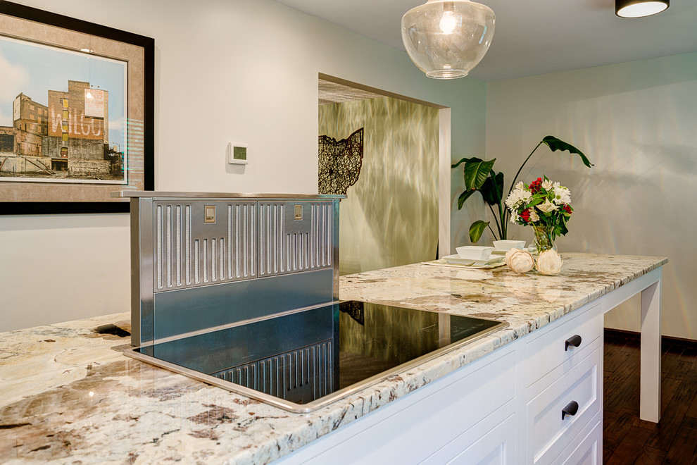Photo of a mid-sized traditional galley eat-in kitchen in Columbus with a double-bowl sink, shaker cabinets, white cabinets, granite benchtops, white splashback, subway tile splashback, stainless steel appliances, medium hardwood floors and with island.