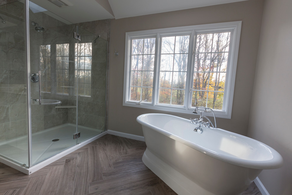Freestanding bathtub - mid-sized transitional master gray tile and porcelain tile porcelain tile and gray floor freestanding bathtub idea in New York with flat-panel cabinets, gray cabinets, a two-piece toilet, gray walls, an undermount sink, quartz countertops and a hinged shower door