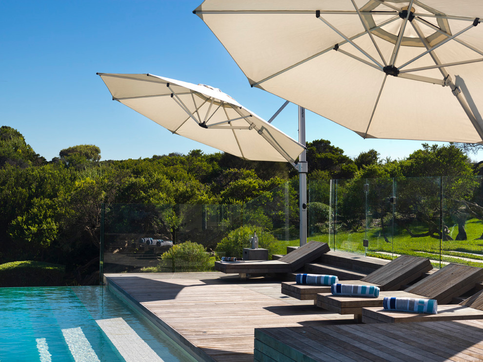 Photo of a large contemporary rectangular infinity pool in Melbourne with decking.