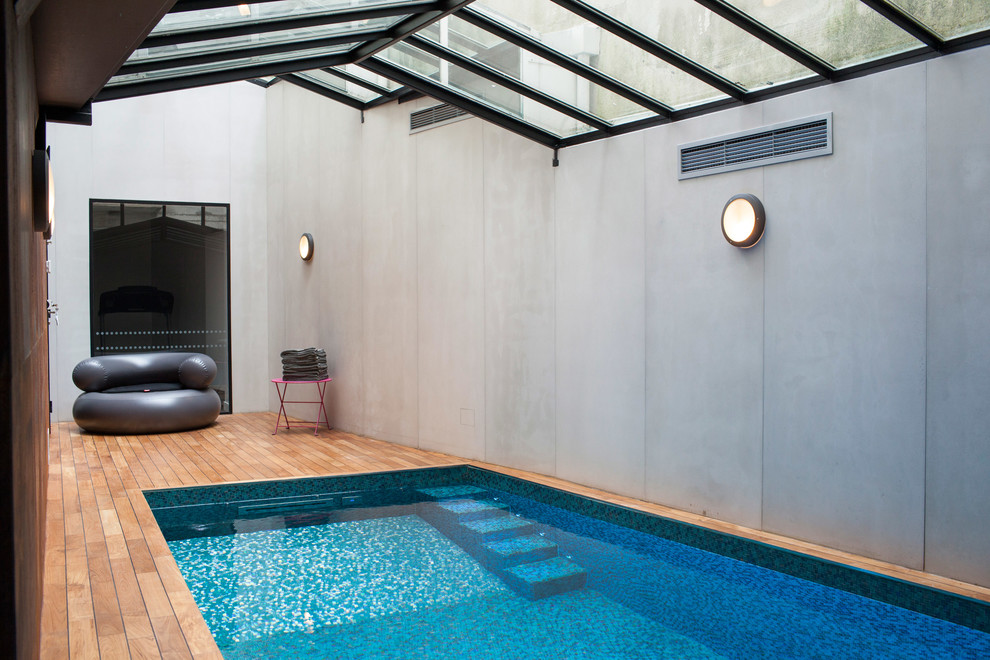This is an example of a mid-sized contemporary indoor rectangular lap pool in Paris with decking.