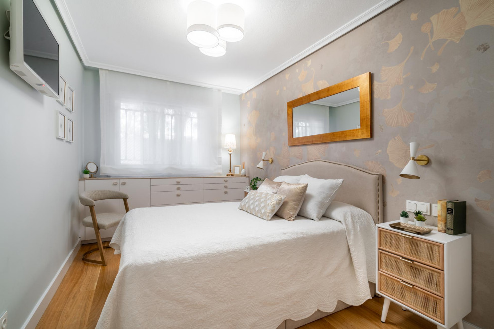 Immagine di una camera matrimoniale classica di medie dimensioni con pareti beige, pavimento in legno massello medio, pavimento marrone e carta da parati
