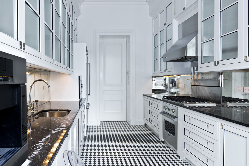 Small contemporary galley separate kitchen in New York with an undermount sink, flat-panel cabinets, white cabinets, granite benchtops, mirror splashback, stainless steel appliances, ceramic floors and no island.