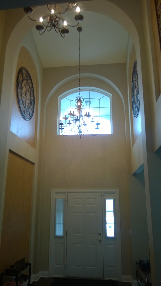 Foyer - large transitional medium tone wood floor foyer idea in Chicago with beige walls