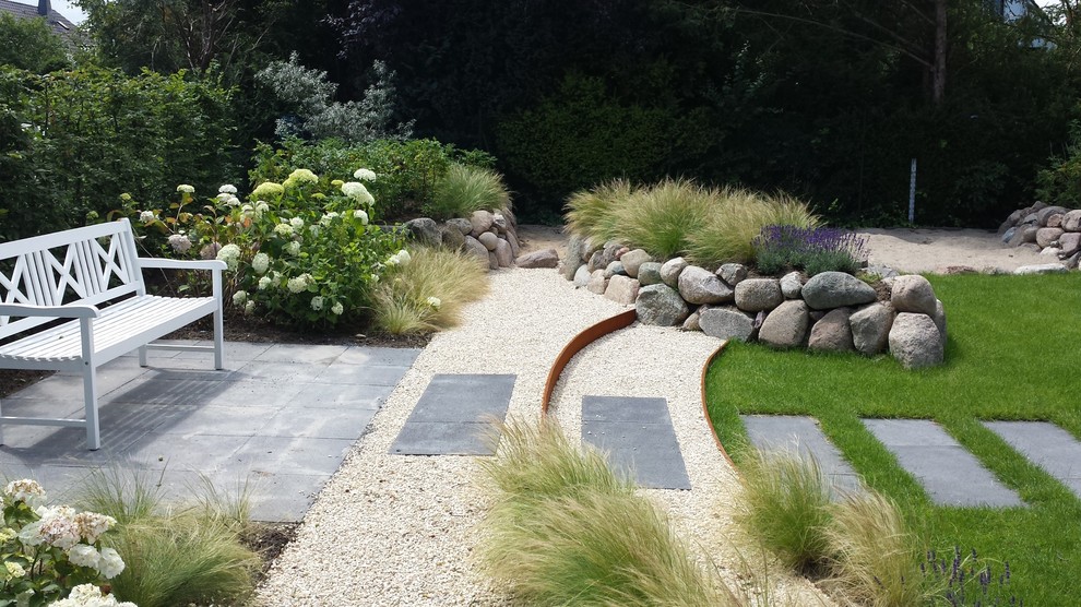 Design ideas for a mid-sized beach style full sun garden for summer in Dusseldorf with a garden path and gravel.