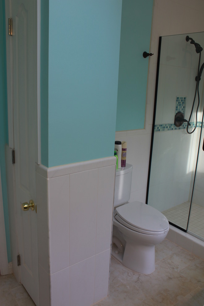 Example of a large transitional white tile and ceramic tile ceramic tile drop-in bathtub design in DC Metro with an undermount sink, raised-panel cabinets, dark wood cabinets, granite countertops, a two-piece toilet and blue walls