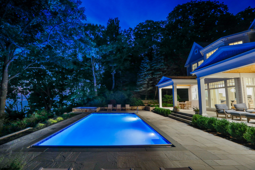 Ispirazione per una piscina monocorsia tradizionale rettangolare di medie dimensioni e dietro casa con pavimentazioni in pietra naturale