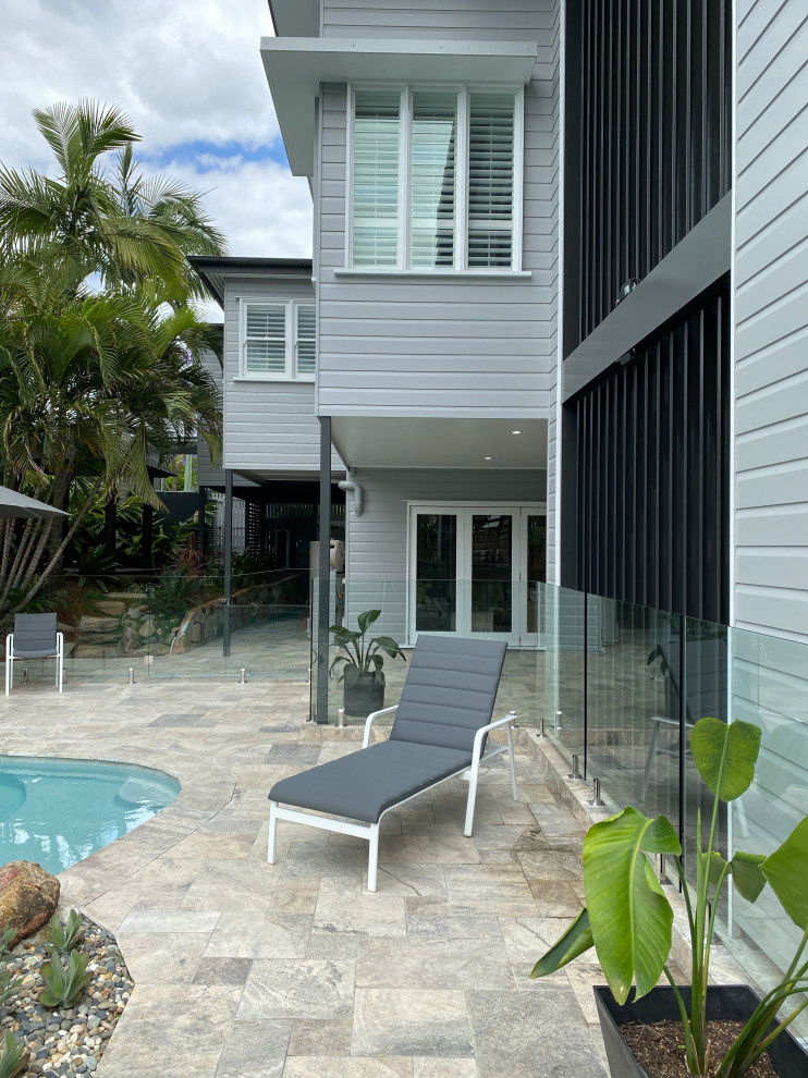 Großer Moderner Pool hinter dem Haus in individueller Form mit Sichtschutz und Natursteinplatten in Brisbane