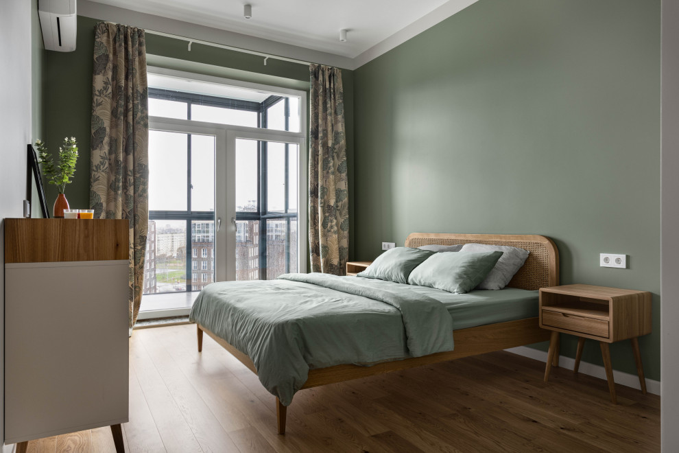 Photo of a medium sized scandinavian master bedroom in Saint Petersburg with green walls, medium hardwood flooring, no fireplace and brown floors.