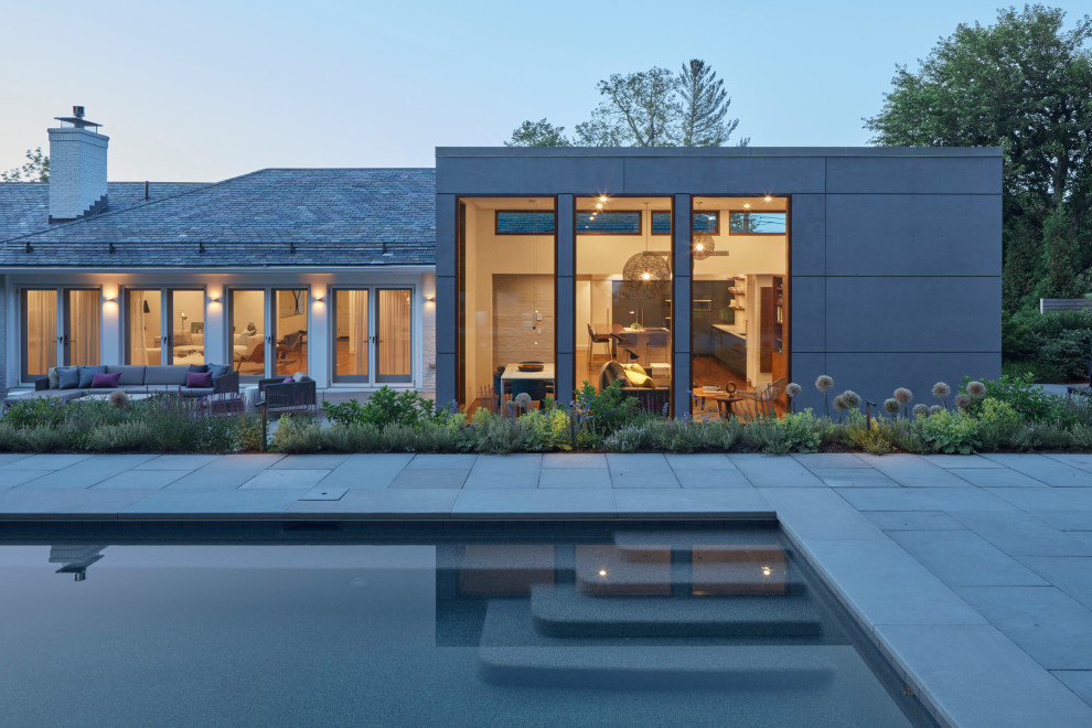 Contemporary one-storey grey house exterior in Boston with concrete fiberboard siding and a flat roof.