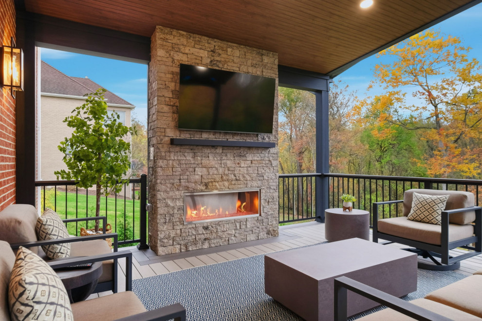 Example of a mid-sized transitional backyard second story mixed material railing deck design with a fireplace and a roof extension