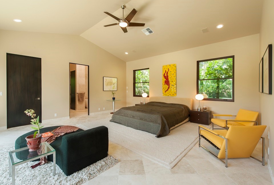 This is an example of a mid-sized contemporary master bedroom in Phoenix with beige walls and travertine floors.